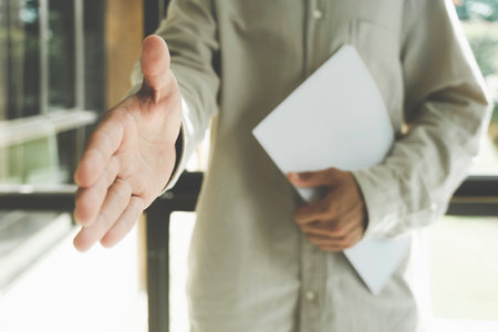 Close up agent reach out hand to camera handshake client.の写真素材