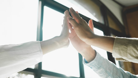 Shot of a group of colleagues giving each other a high five.