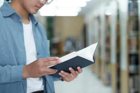 University students reading books in library for research.