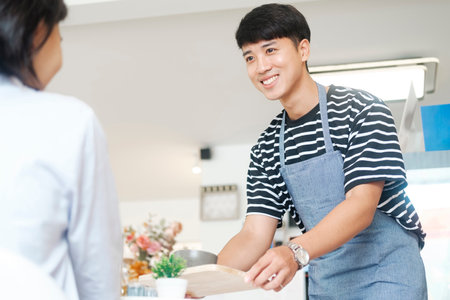 Waiter serving a cup of coffee to customer.の写真素材