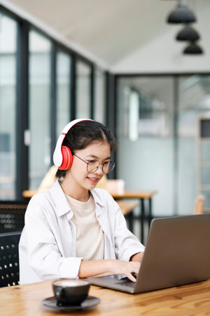 Young collage student using computer and mobile device studying online...