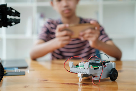 Asian teenager doing robot project in science classroom. technology of robotics programing and STEM education concept.の写真素材
