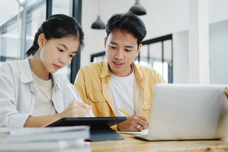 Young students campus helps friend catching up and learning.の写真素材