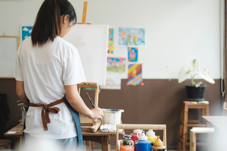 Crafting Inspiration: Female Artist Sketching and Painting in Workshopの写真素材