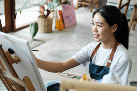 Crafting Inspiration. Female Artist Sketching and Painting in Workshopの写真素材