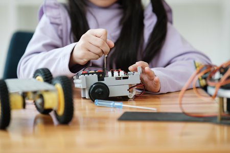 STEM education concept. Asian young girl learning robot design.