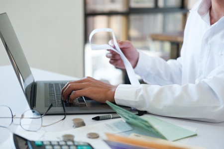 Accountant filling in items from a bill and use computers to calculate financial budgets