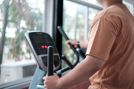 A man is smiling while riding a stationary bike in a gymの写真素材