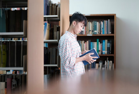 University Student Reading Book in Library