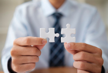 Businessman Holding Puzzle Pieces Symbolizing Problem Solving and Strategyの写真素材