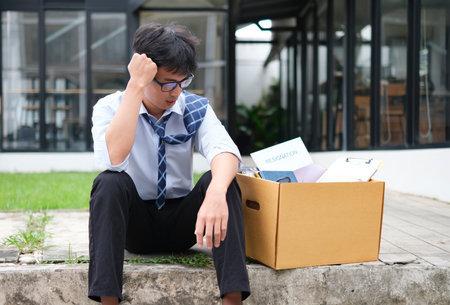 Unemployed Businessman Sitting with Box After Losing Jobの写真素材