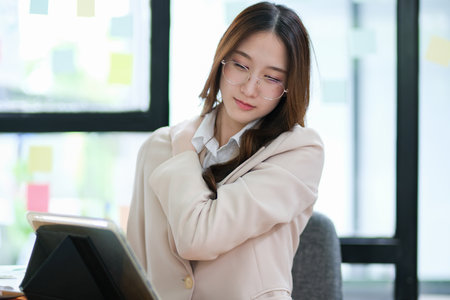 Businesswoman feeling discomfort while working at her deskの写真素材