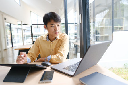 Student studying online and preparing for exams with digital devices and booksの写真素材