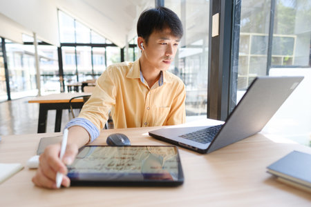 Student studying online and preparing for exams with digital devices and booksの写真素材