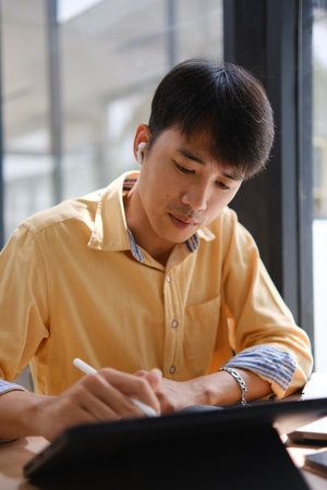 Student studying online and preparing for exams with digital devices and booksの写真素材