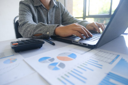 Professional businessman using computer laptop analyzing financial graphs investment marketing data.の写真素材