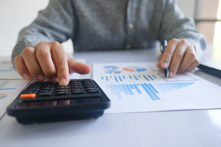 Close up accountant banker or bookkeeper making calculations with calculator.の写真素材