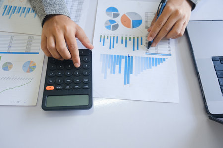 Close up accountant banker or bookkeeper making calculations with calculator.の写真素材