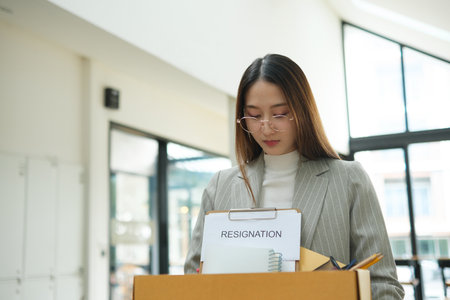 Resignation concept. Businesswoman packing personal belongings deciding resignation change of job or...