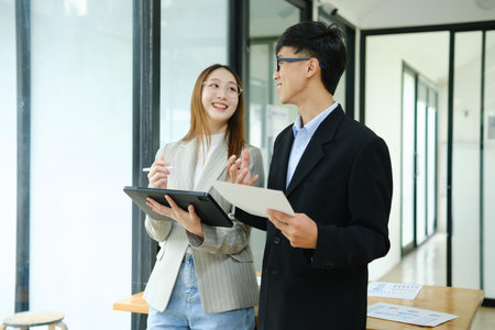 Two business people discuss financial strategy and collaborate with colleagues.の写真素材