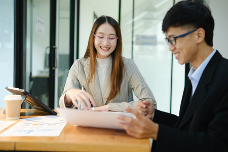 Two business people discuss financial strategy and collaborate with colleagues.の写真素材