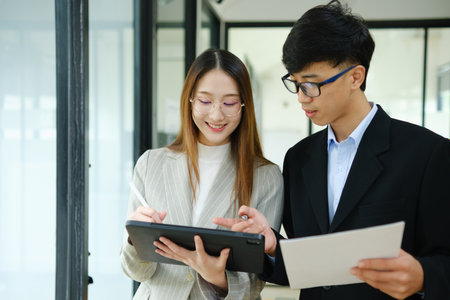 Two business people discuss financial strategy and collaborate with colleagues.の写真素材