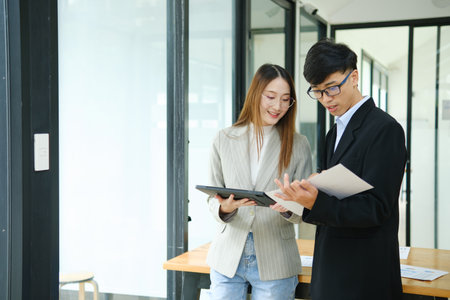 Two business people discuss financial strategy and collaborate with colleagues.の写真素材