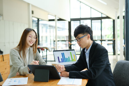 Two business people discuss financial strategy and collaborate with colleagues.の写真素材
