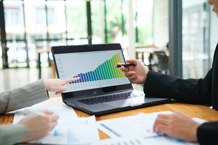 Two business people discuss financial strategy and collaborate with colleagues.の写真素材