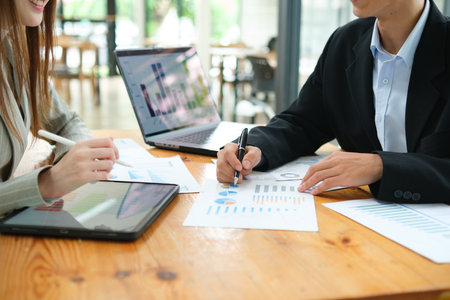 Two business people discuss financial strategy and collaborate with colleagues.の写真素材