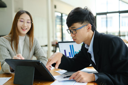 Two business people discuss financial strategy and collaborate with colleagues.の写真素材