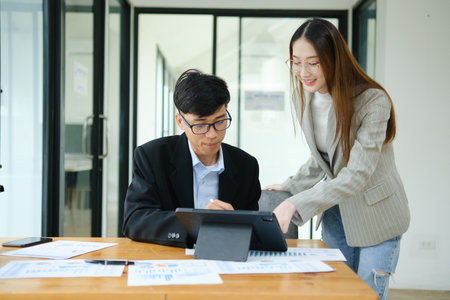 Two business people discuss financial strategy and collaborate with colleagues.の写真素材