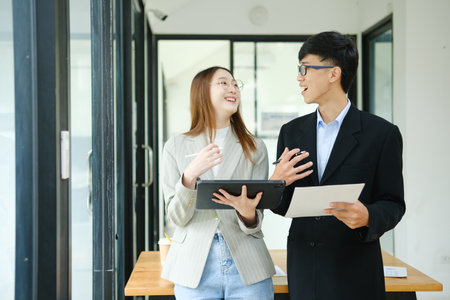 Two business people discuss financial strategy and collaborate with colleagues.の写真素材