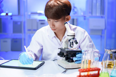 Scientist recording the results of the study in a laboratory journal.の写真素材