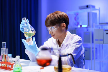 A young male scientist examining a in beaker a lab.