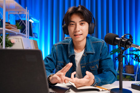 Smiling man podcaster make audio podcast with headphones and microphone in modern home studio.の写真素材