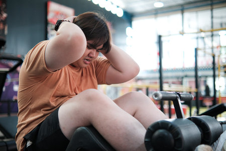 Overweight Man Exercising with Sit Ups at Gym Fitness and Weight Loss Concept.の写真素材