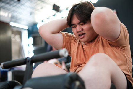 A plus size mans effort and struggle during an abdominal workout for a new lifestyle.の写真素材