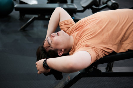 An exhausted man taking a break during his gym training. Real effort.の写真素材