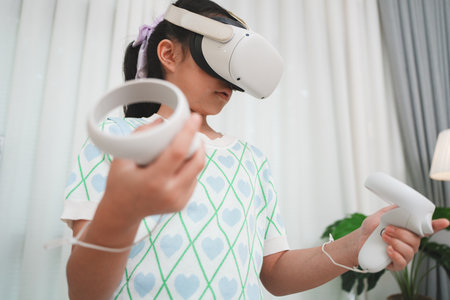 A young Asian girl explores , using a VR headset and controllers for gaming experience. This is the...