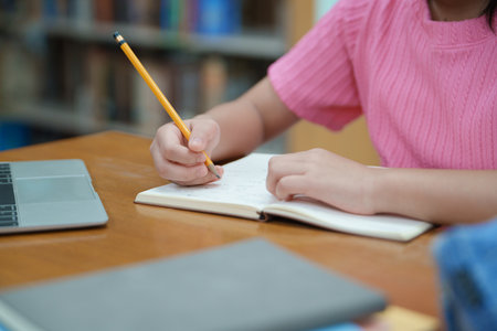 Student girl hand doing exam checking notebookの写真素材