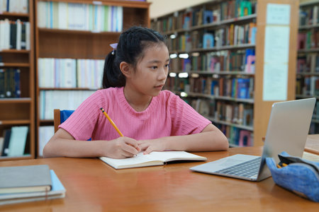 Student learning online class by using laptop computer and writing notebook at workplace, E learning and online working concept.の写真素材