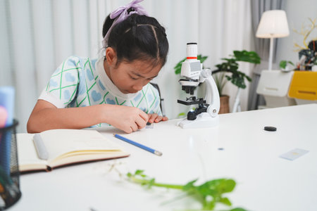 Elementary Girl Placing Slide on Microscope STEM Science Experiment Procedureの写真素材