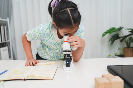 Young student exploring microscope highlighting STEM curiosity and scientific learning skillsの写真素材