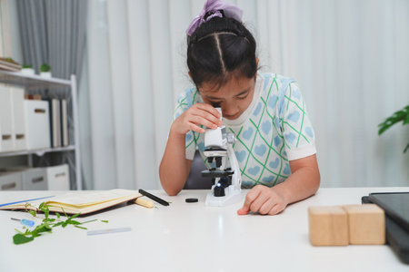Young student exploring microscope highlighting STEM curiosity and scientific learning skillsの写真素材