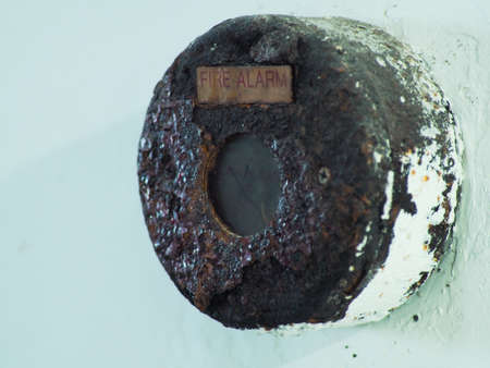 Close up shoot of rustic fire alarm that installed on  white wallの写真素材