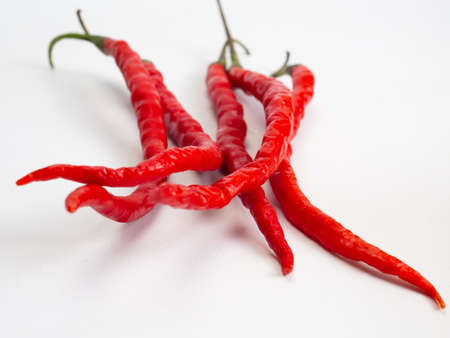 Close up shoot of red hot chillies, captured on a white backgroundの写真素材