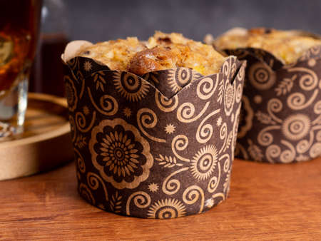 Banana muffin cakes with a cup of iced coffee placed on a wooden table with black dark backgroundの写真素材