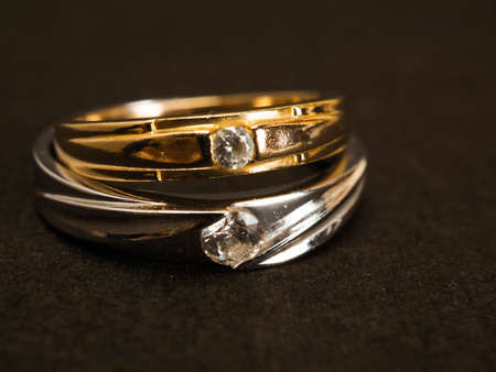 Close up shoot of gold wedding ring with beautiful diamond on a black backgroundの写真素材
