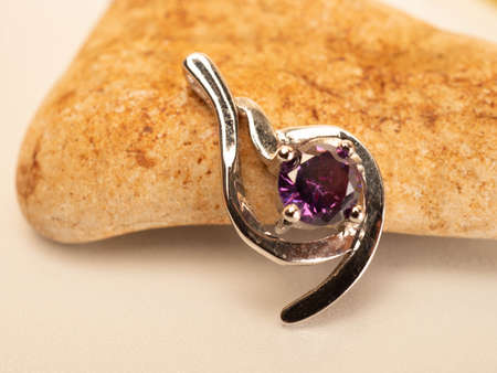 Close up shot of white gold pendat with shiny purple stoneの写真素材